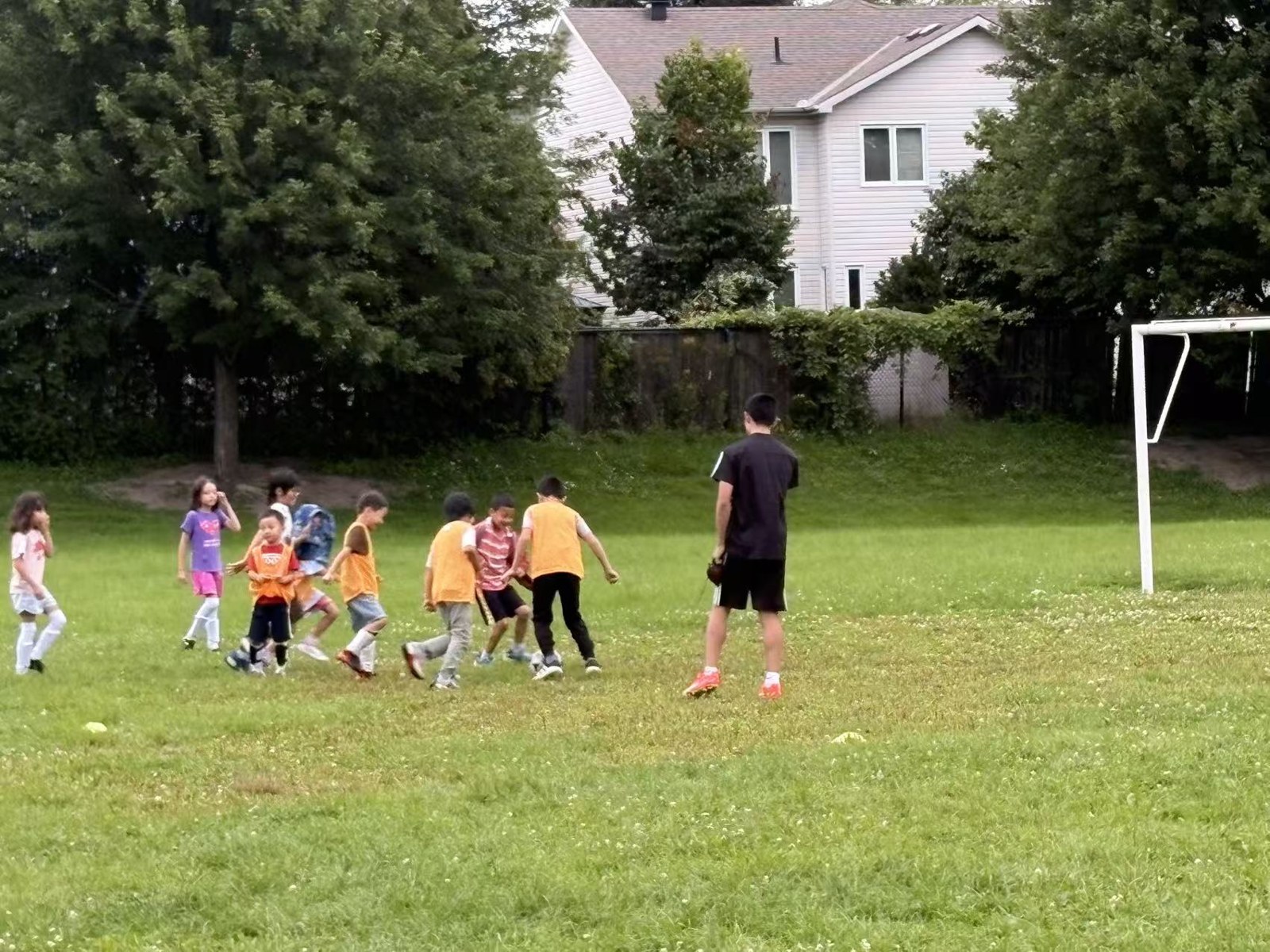 A coach watching children play during the summer soccer match