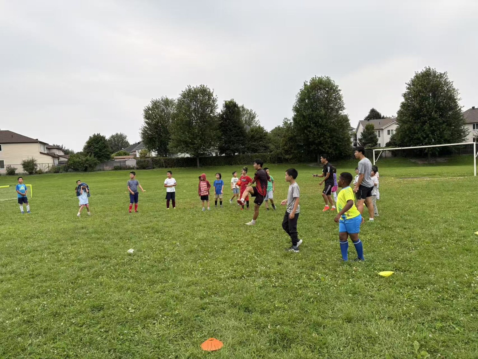 Three coaches leading young players through training and games