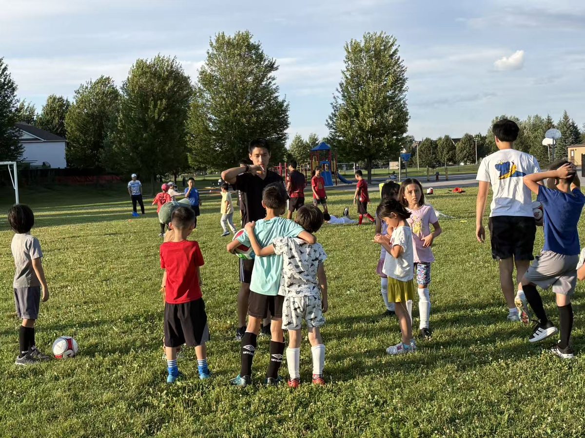 Four coaches guiding groups of children through passing drills
